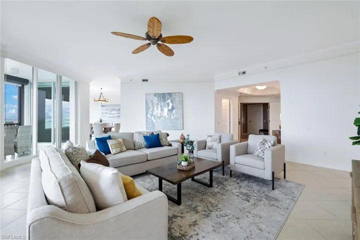 Tiled living room featuring ornamental molding and ceiling fan
