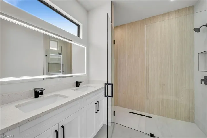 Bathroom with tile patterned flooring, vanity, and a shower with shower door