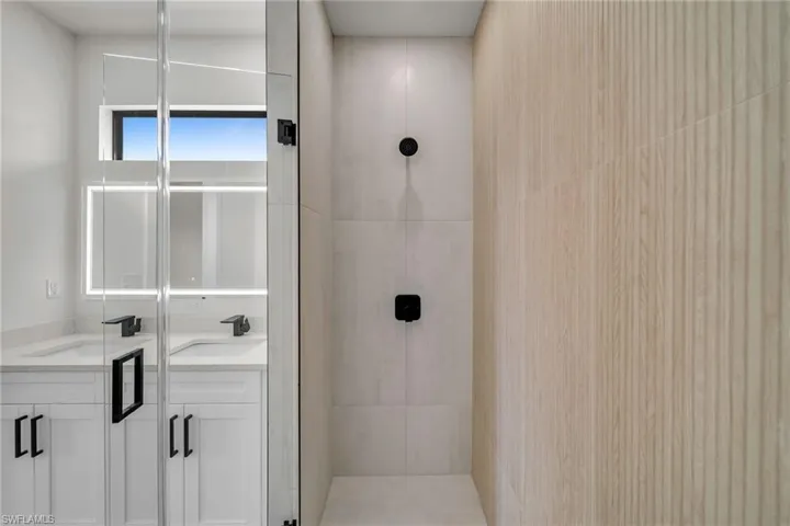 Bathroom featuring vanity and a shower with door