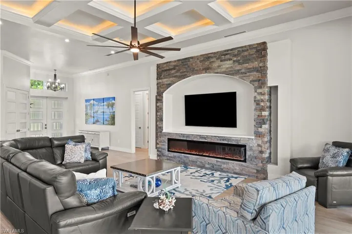 Spacious living area featuring a stacked stone media wall with an integrated electric fireplace