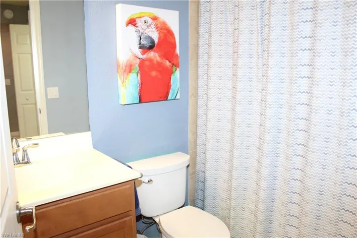 Full bath featuring a shower with shower curtain, vanity, and a textured wall