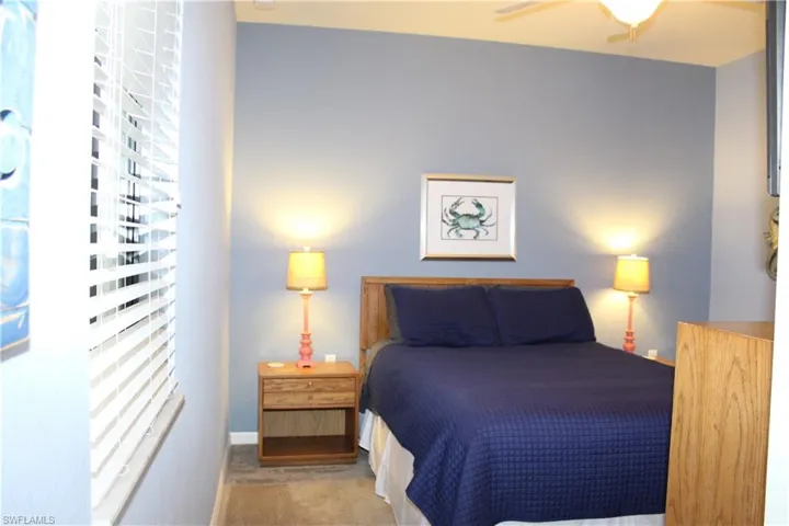 Carpeted bedroom featuring ceiling fan