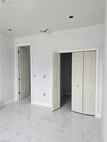 Unfurnished bedroom featuring light tile patterned flooring and a closet