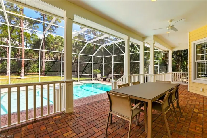 Swimming pool with a sunroom, a patio, glass enclosure, and outdoor dining area