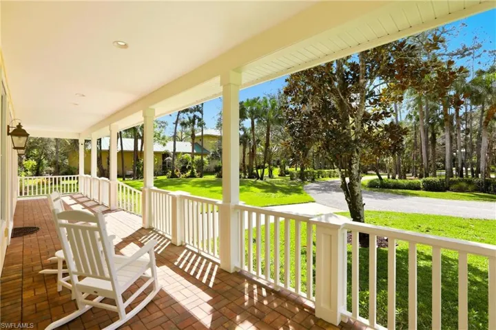 Wooden porch featuring a lawn