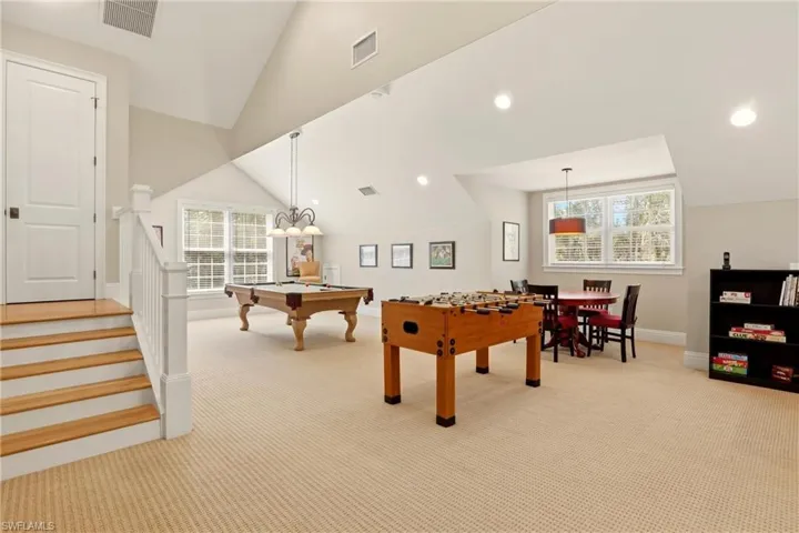 Rec room with light carpet, vaulted ceiling, and pool table