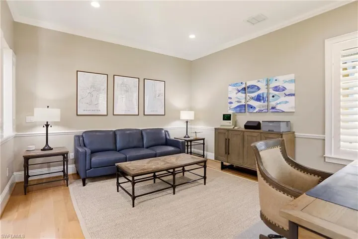 Living room with light wood-style floors, crown molding, a desk, and recessed lighting