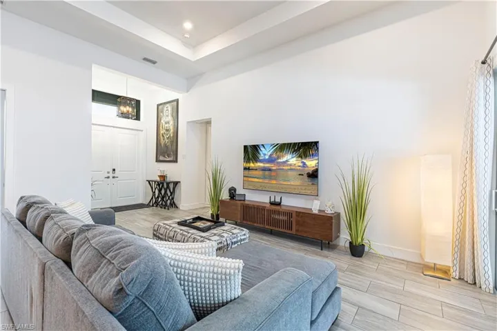 Living area with wood finish floors, baseboards, and recessed lighting