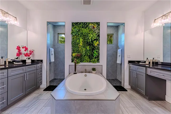 Bathroom featuring vanity, a bath, and a walk in shower