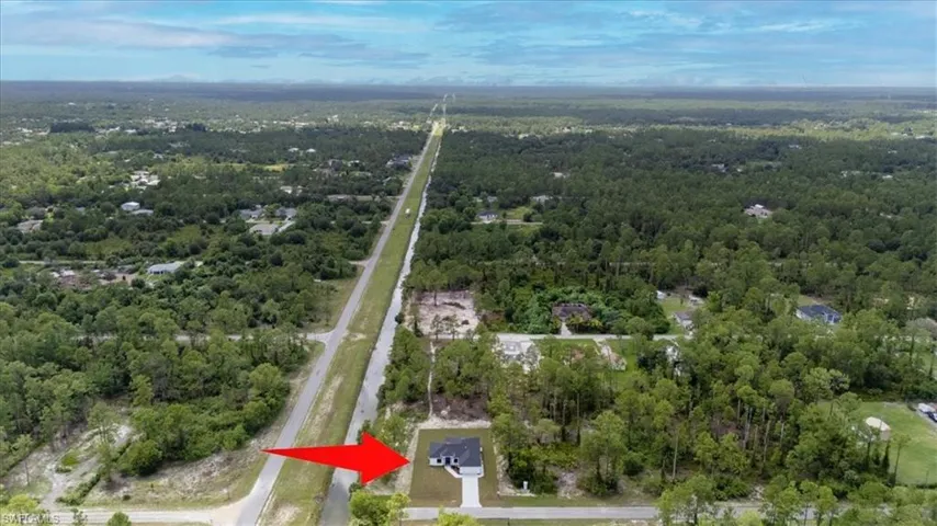 Aerial view of property and surrounding area featuring a heavily wooded area