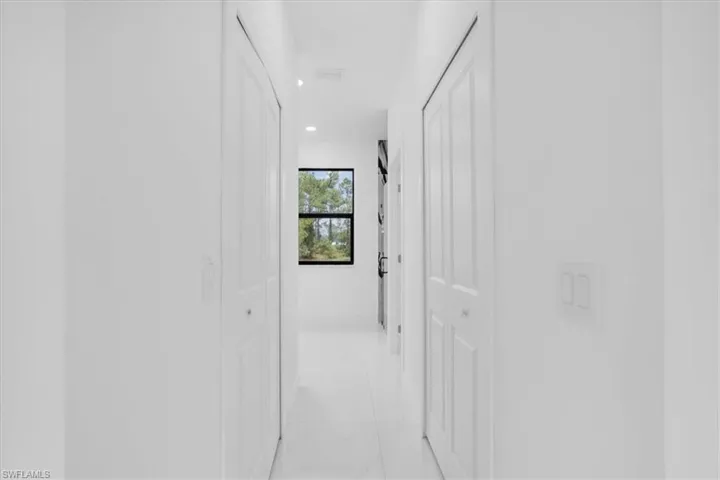 two walking closets in Hallway walrecessed lighting and light tile patterned flooring