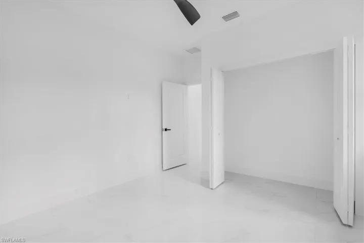 2nd bedroom featuring light marble finish floors, a closet, and ceiling fan