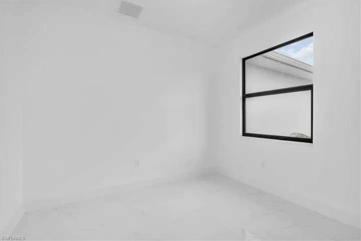 Unfurnished room with baseboards and light marble finish floors