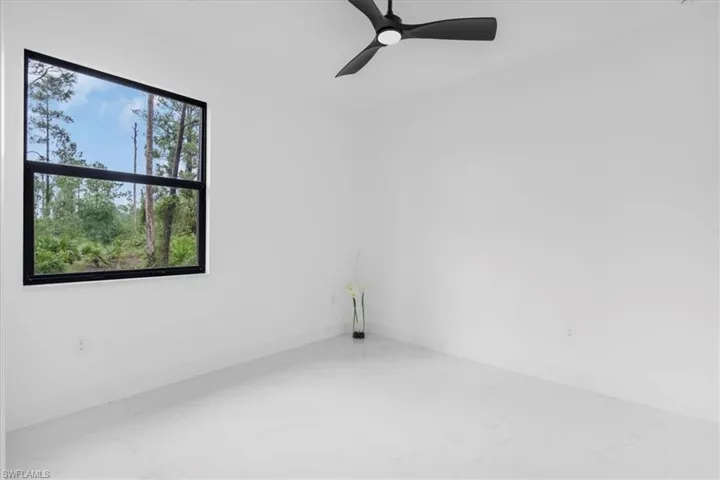 1st bedroom featuring ceiling fan and marble finish flooring