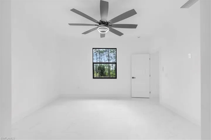 Unfurnished room with light marble finish flooring and ceiling fan