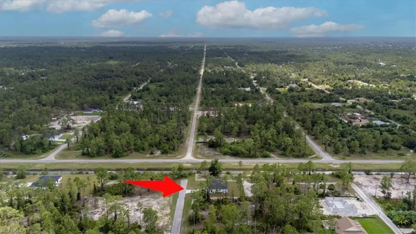 Aerial view of property and surrounding area with a forest