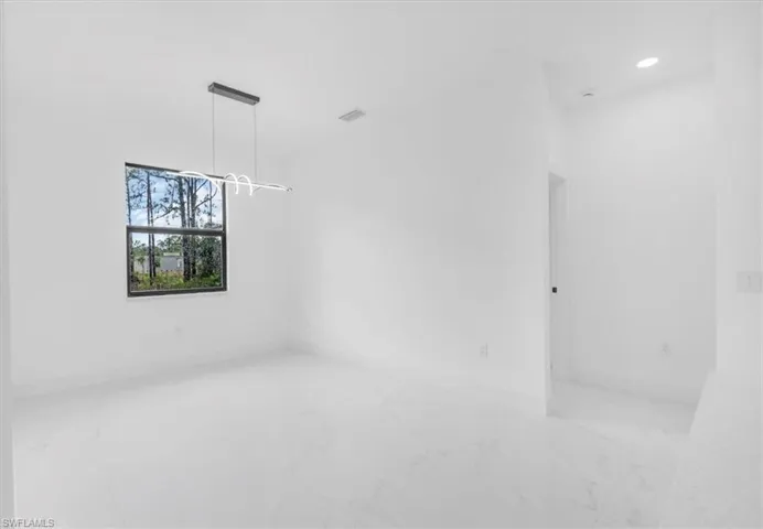 1st bedroom featuring light marble finish floors and recessed lighting