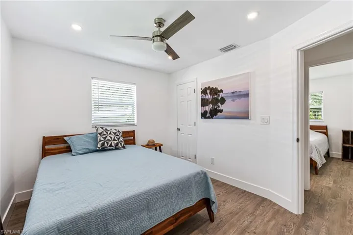 Bedroom with multiple windows, ceiling fan, and hardwood / wood-style floors