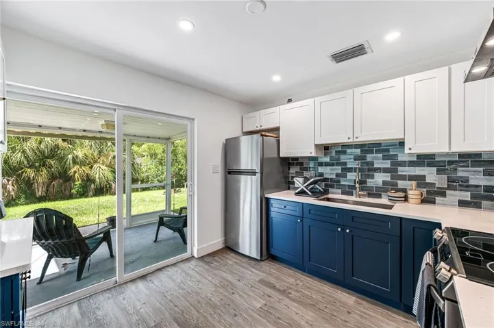 Kitchen featuring sink, light hardwood / wood-style flooring, decorative backsplash, and stainless steel appliances