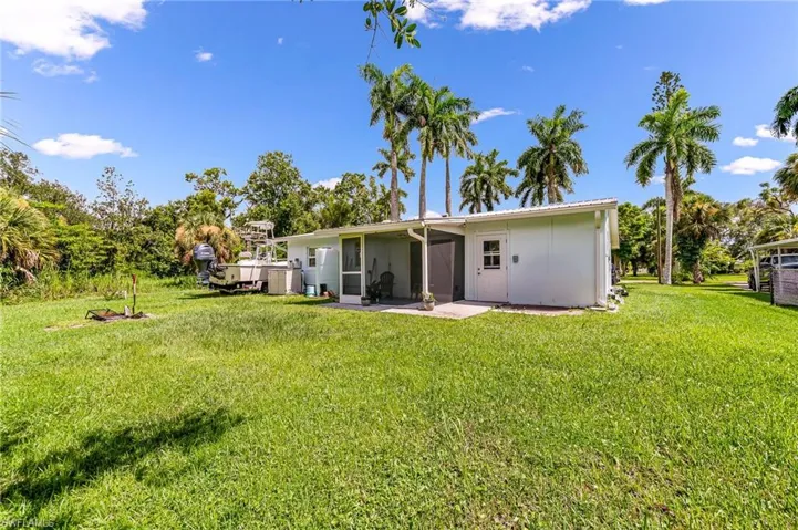 Back of house with a yard and a patio area