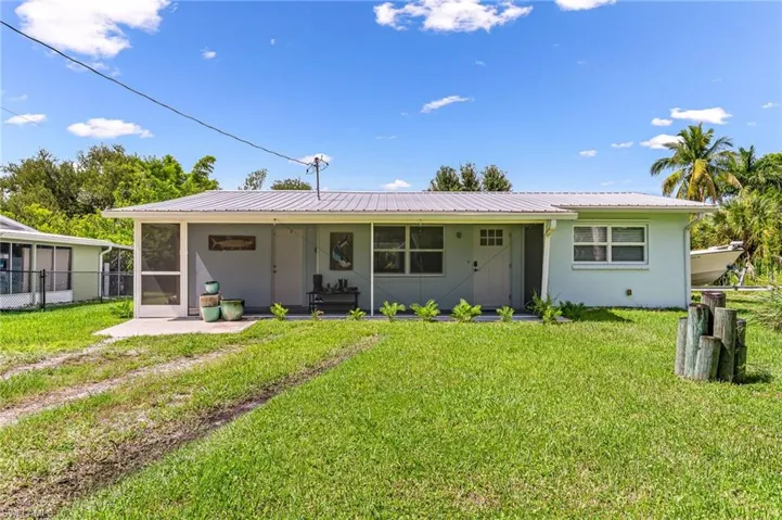 View of front of property featuring a sunroom and a front yard