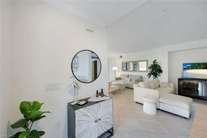 Living room featuring ornamental molding and light tile patterned flooring