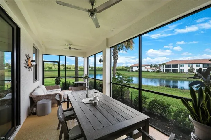 Sunroom featuring a ceiling fan and a water view