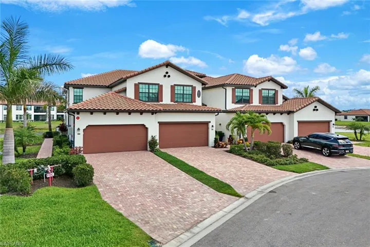 Mediterranean / spanish-style home featuring stucco siding, decorative driveway, a tiled roof, a front yard, and an attached garage