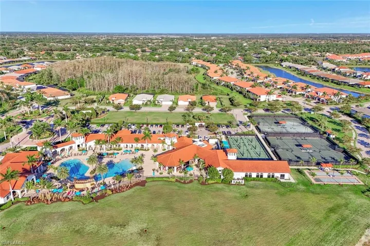 Aerial view of property and surrounding area featuring a nearby body of water, nearby suburban area, and a pool