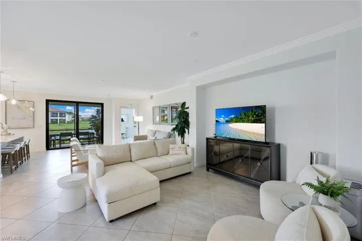 Living area featuring light tile patterned flooring and ornamental molding