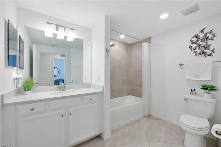 Full bath featuring toilet, shower / tub combo, baseboards, vanity, and recessed lighting