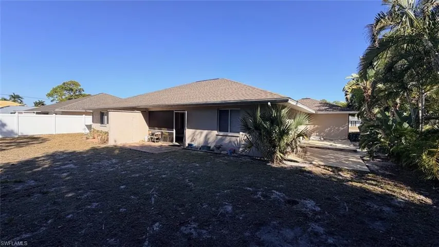 Rear view of Duplex with stucco siding, roof with shingles, and a patio