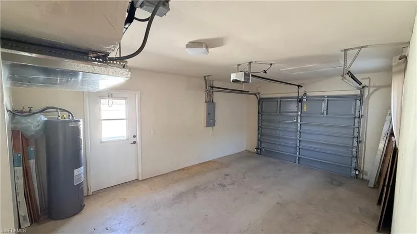 Right Unit: Garage with water heater, electric panel, and a garage door opener