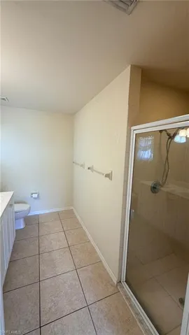 Right Unit: Full bath with vanity, a shower stall, and light tile patterned flooring