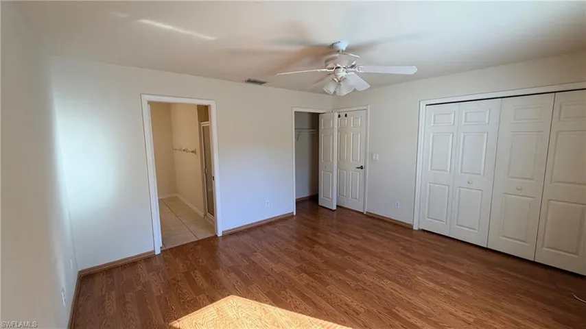 Right Unit: Unfurnished bedroom with light wood-style floors, two closets, ceiling fan, and ensuite bathroom