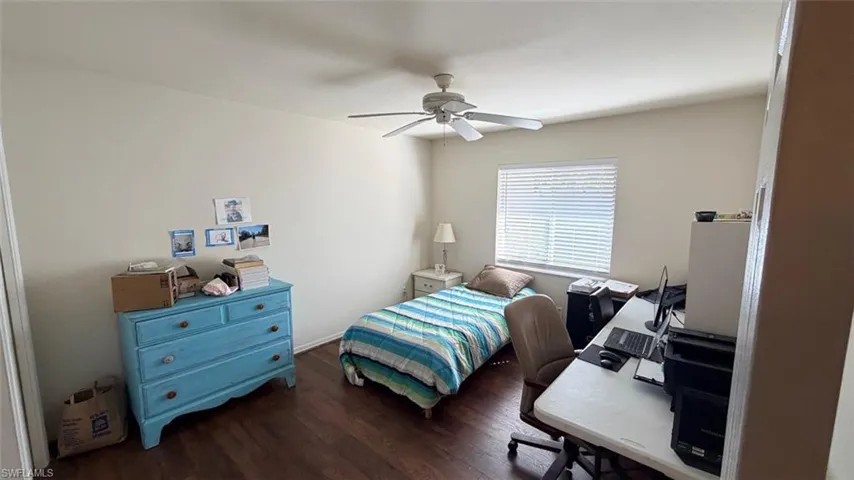 Left Unit: Bedroom with dark wood finished floors, a ceiling fan, and a desk
