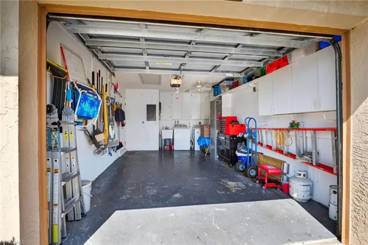 Garage with washing machine and clothes dryer and electric panel
