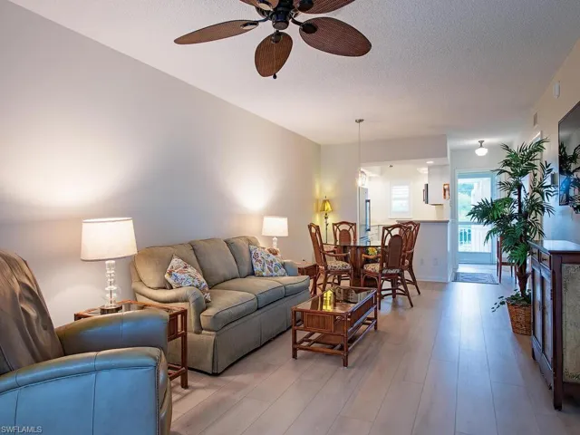 Living room with a textured ceiling, wood finished floors, and ceiling fan