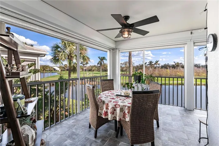 Sunroom / solarium with ceiling fan and a water view
