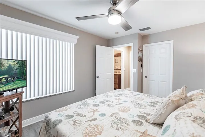 Bedroom with ceiling fan, a closet, and wood-type flooring