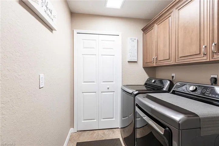 Clothes washing area with cabinets and washer and clothes dryer