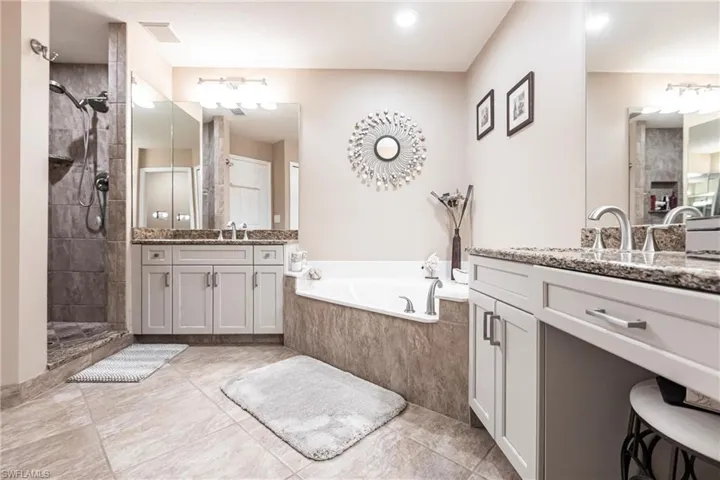 Bathroom featuring independent shower and bath, vanity, and tile patterned flooring
