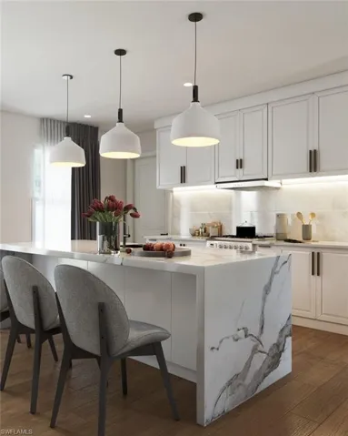Kitchen with pendant lighting, backsplash, light stone countertops, white cabinetry, and dark hardwood / wood-style flooring