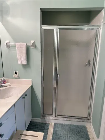 Bathroom featuring walk in shower, tile patterned floors, and vanity