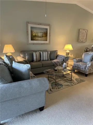 Living room with lofted ceiling and carpet flooring
