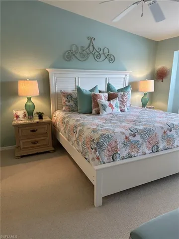 Carpeted bedroom featuring ceiling fan