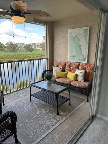 Sunroom / solarium with a water view and ceiling fan