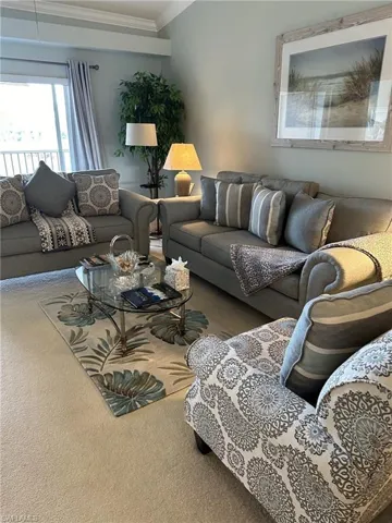 Carpeted living room with crown molding