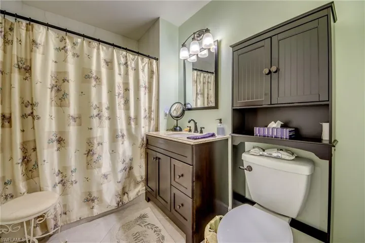 Full bath with a shower with shower curtain, vanity, and light tile patterned floors