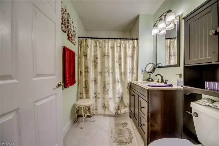Bathroom with vanity, curtained shower, and light tile patterned floors